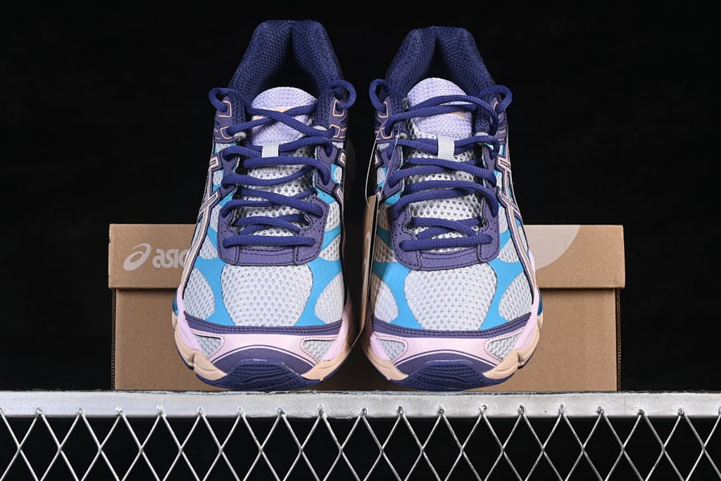 Front view of the pair of multicolor sneakers in front of the box.