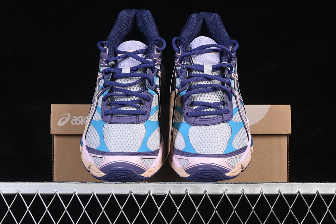 Front view of the pair of multicolor sneakers in front of the box.