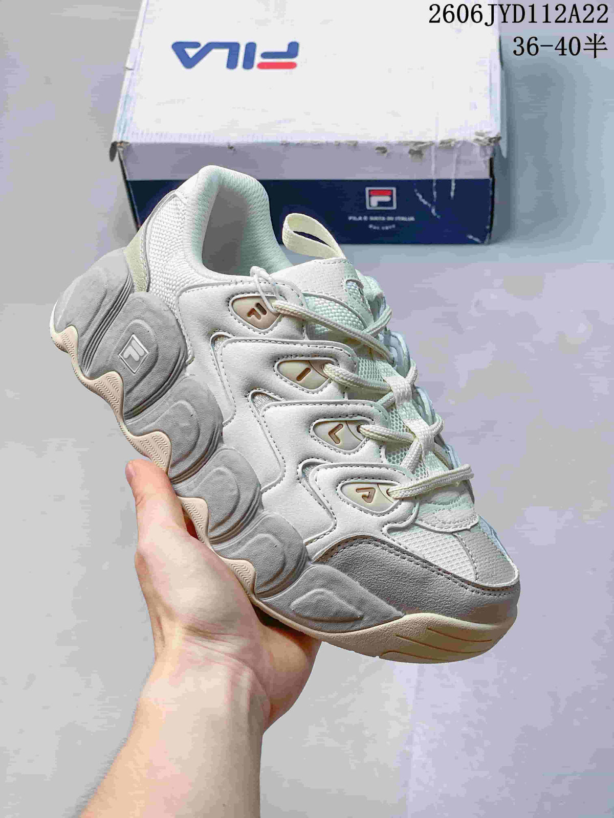 Angled side view of a white and grey FILA chunky sneaker