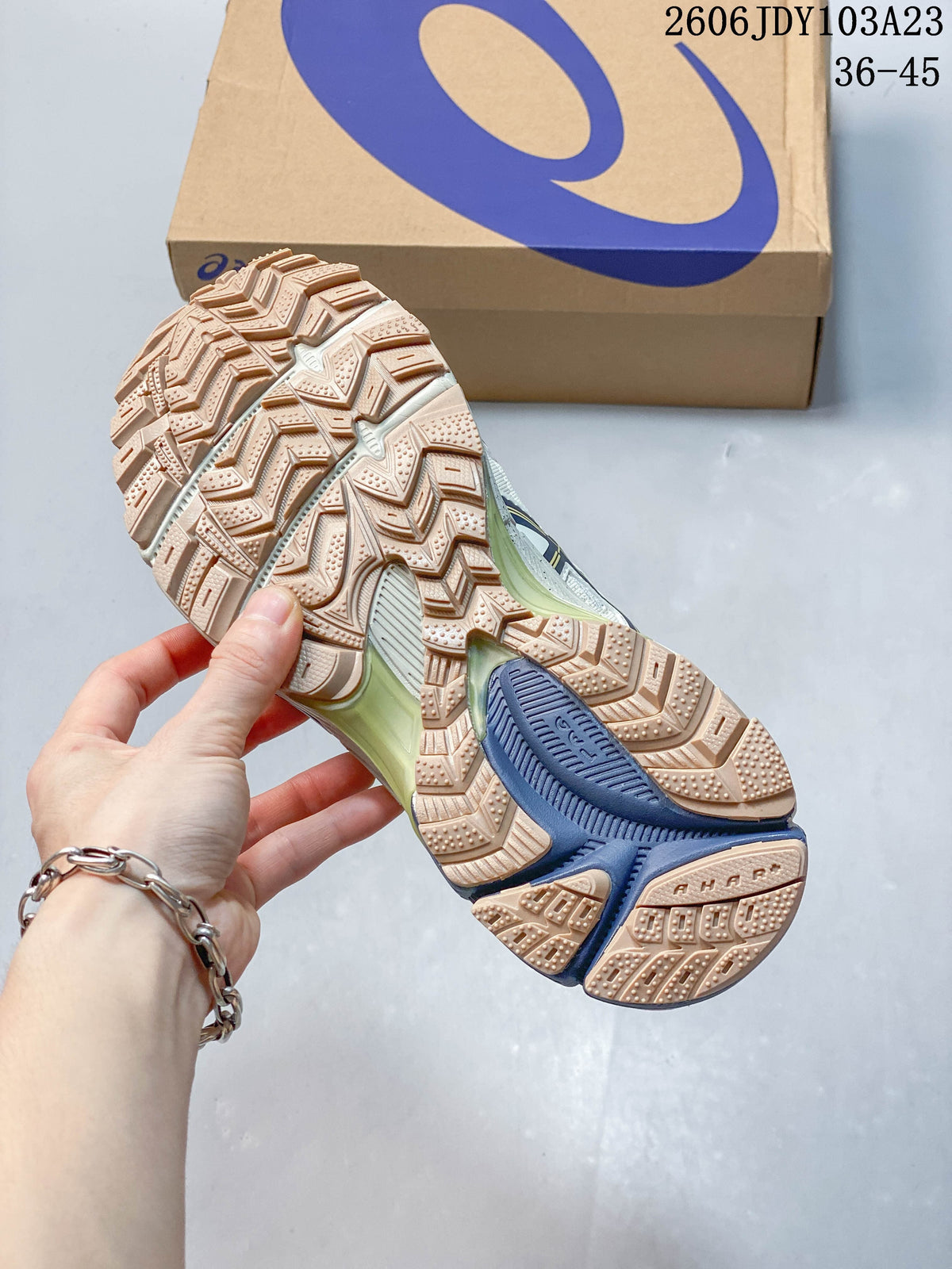 Close-up of the patterned lugged outsole with tan and navy sections