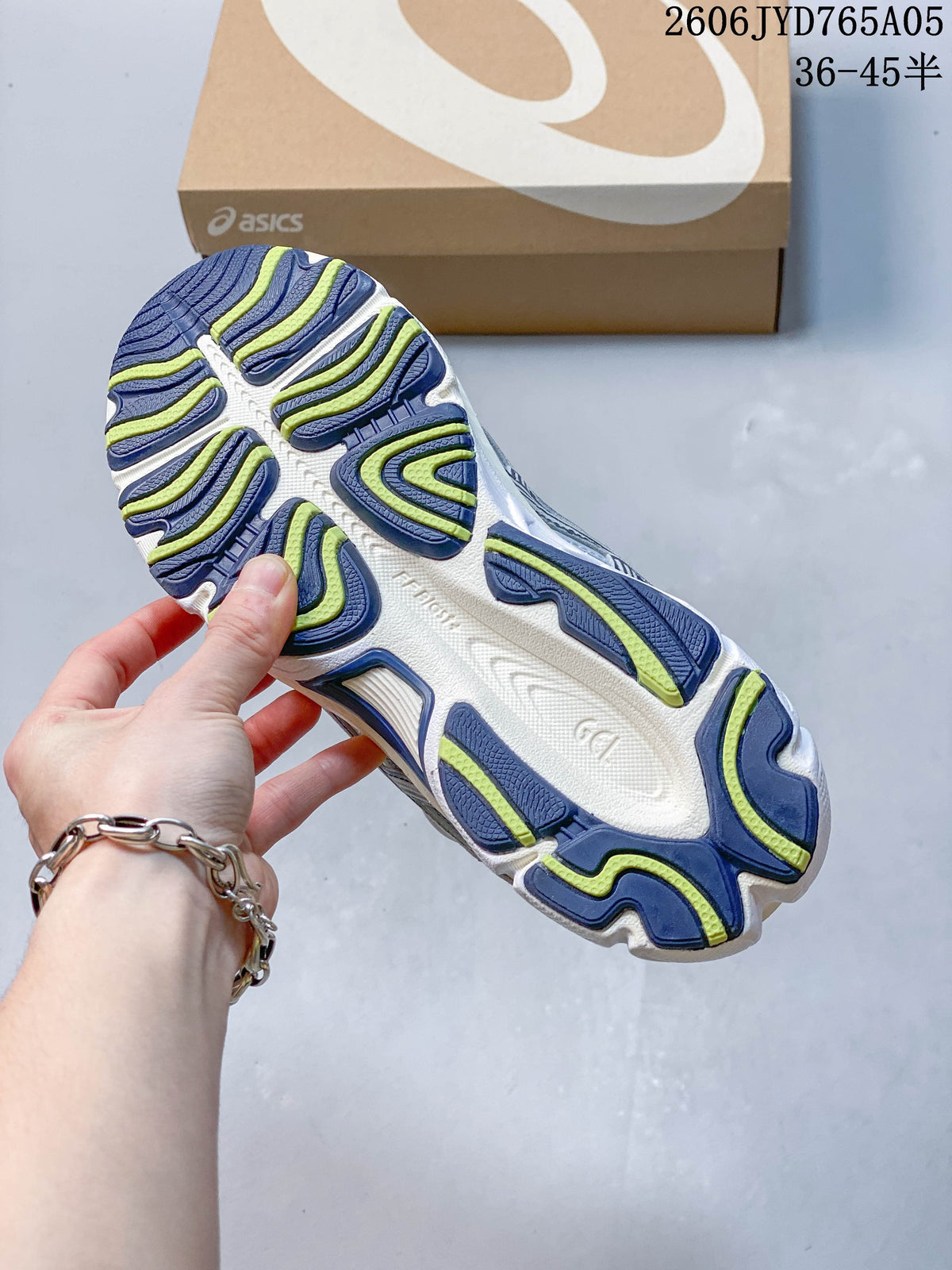 Outsole view of the sneakers, showing navy and lime tread sections.