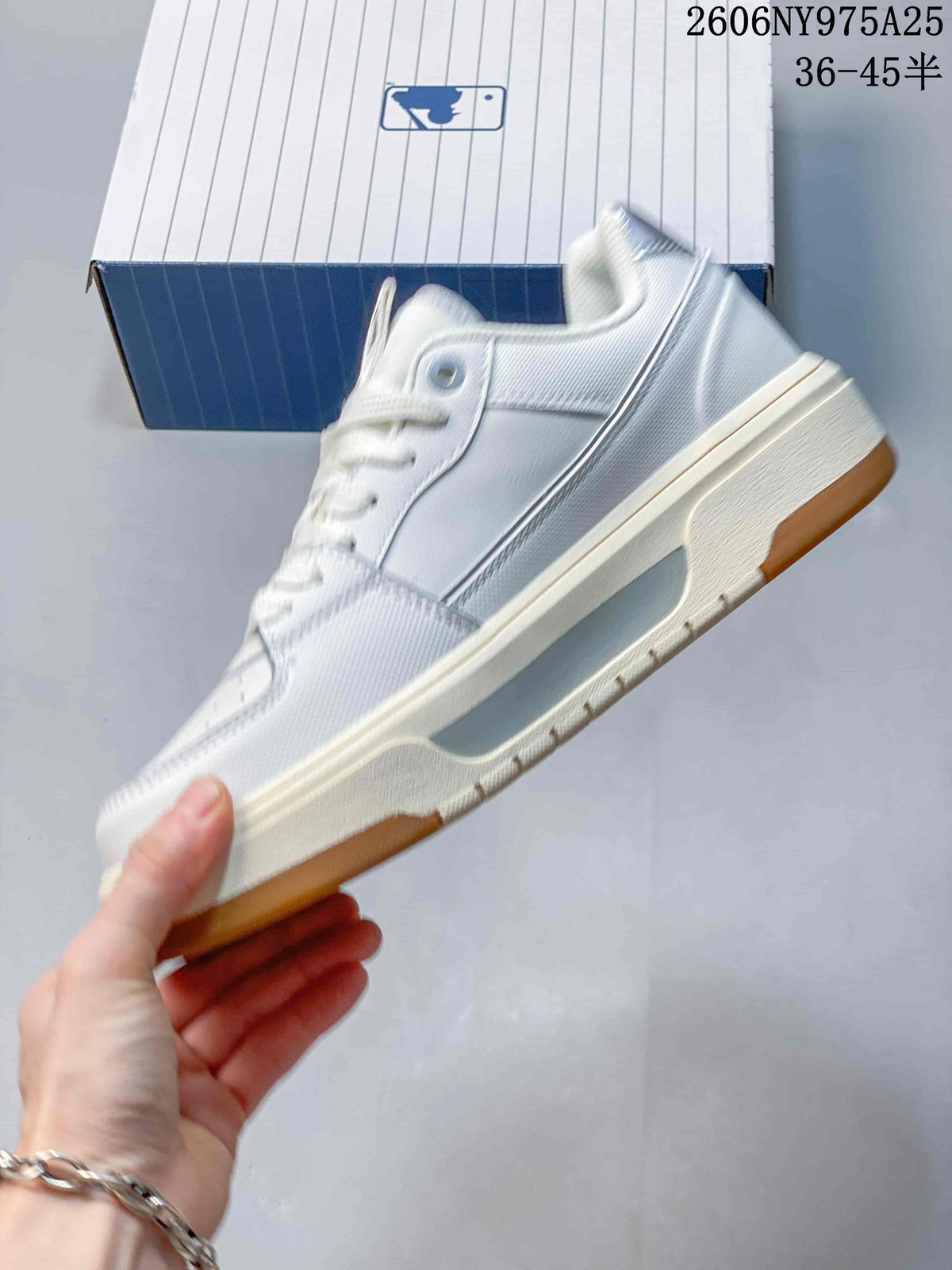 Side profile of a white low-top sneaker with layered panels and a raised midsole.