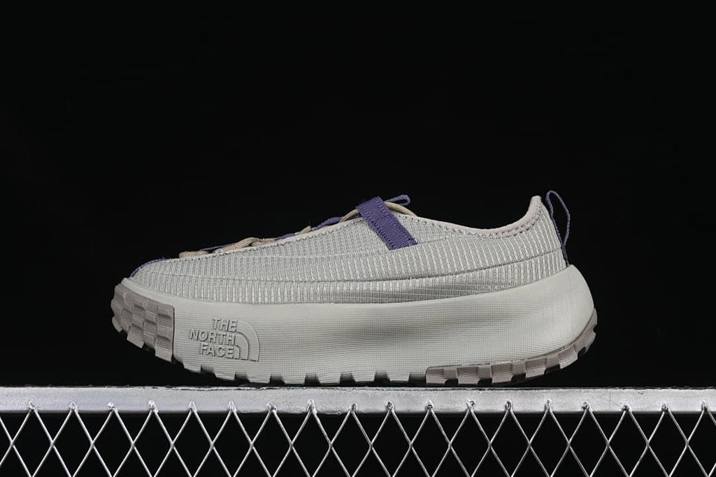 Side view of clay grey The North Face low-top shoes with purple accents.