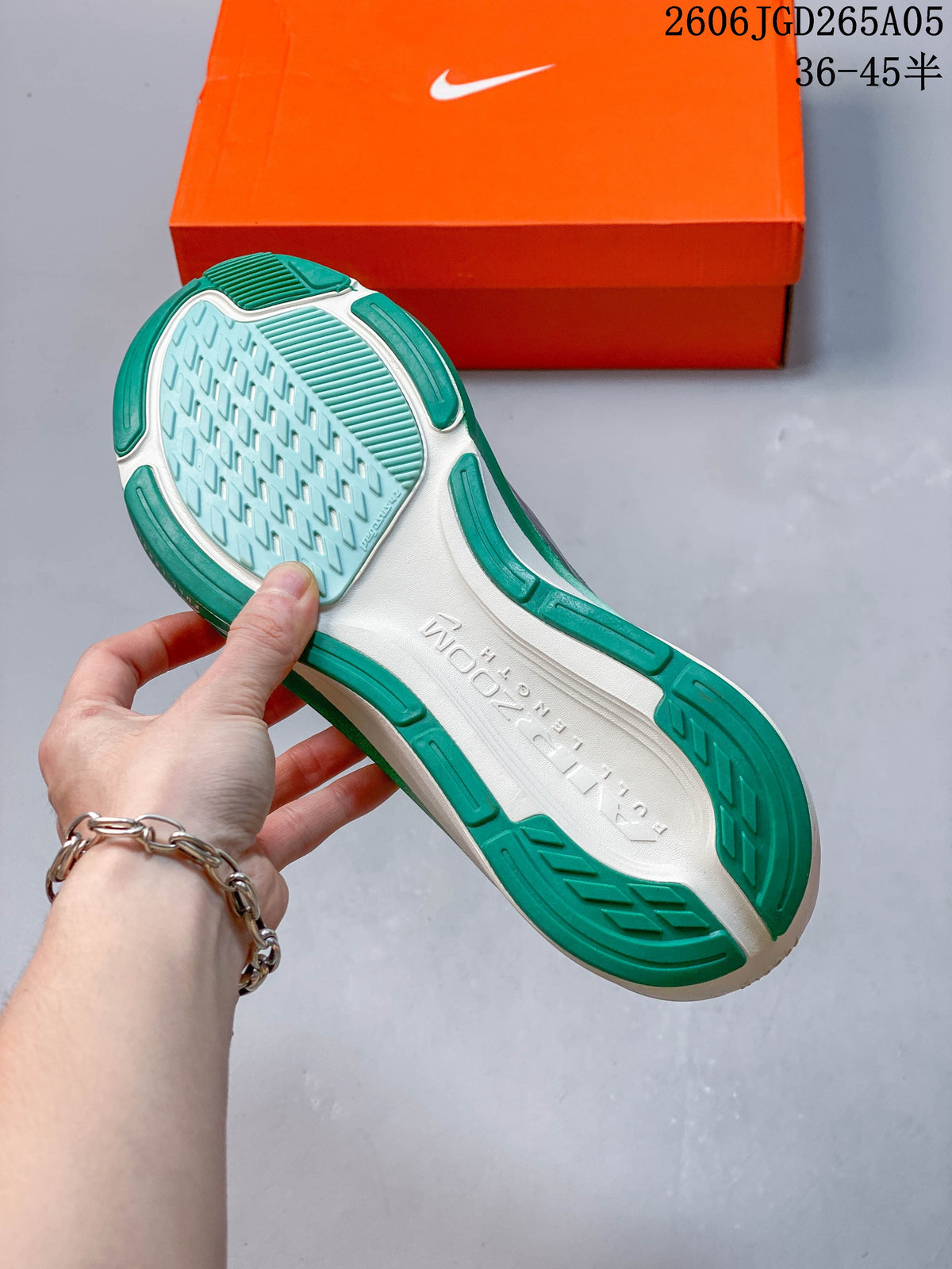 Outsole of the white and green running shoe, with size range text visible in the image