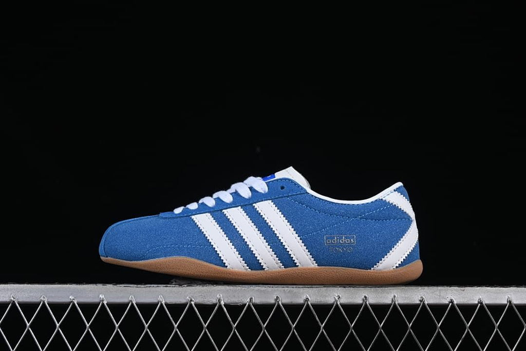 Side profile of a blue and white Adidas Tokyo sneaker with a gum-colored outsole