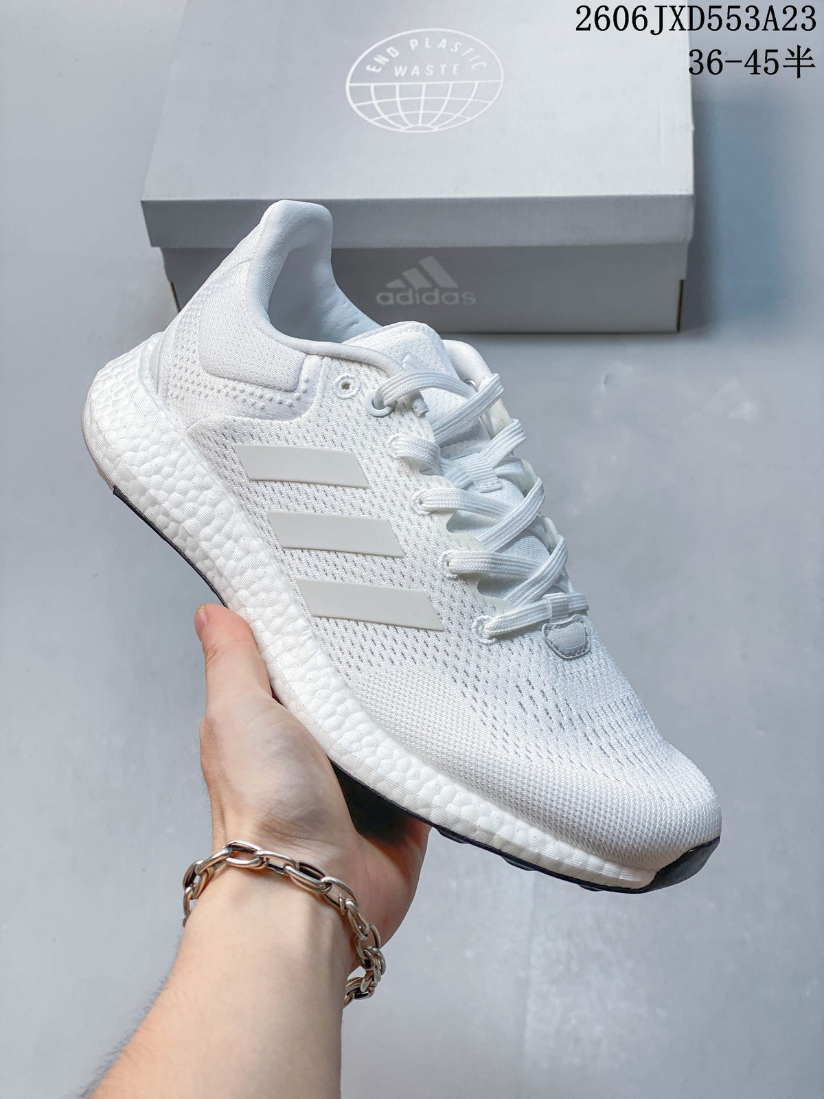 Angled side view of a white Adidas PureBoost 21 running shoe