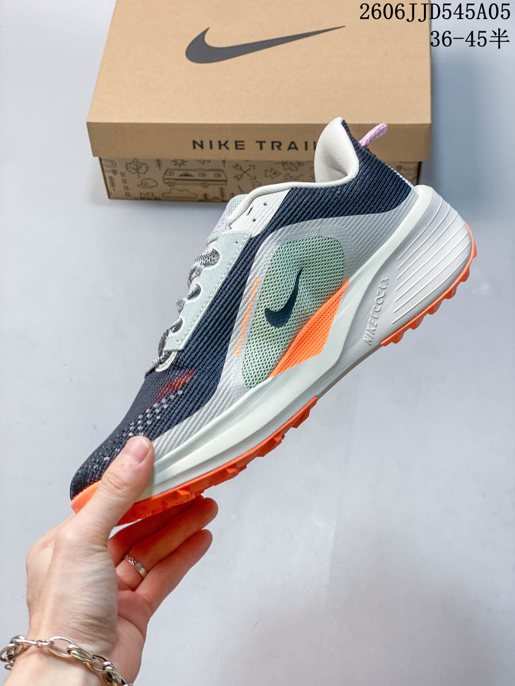 Side profile of the Nike ACG Pegasus Trail 6 with navy, pale green, light gray, and orange details.