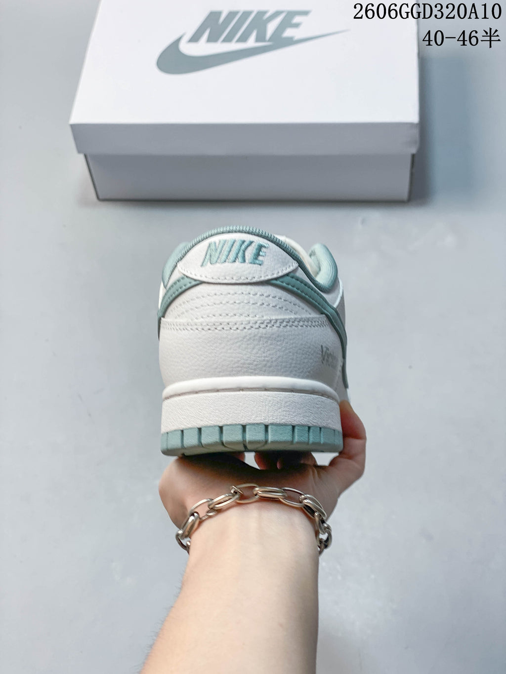 Rear view of a white and sage Nike Dunk Low Retro sneaker.