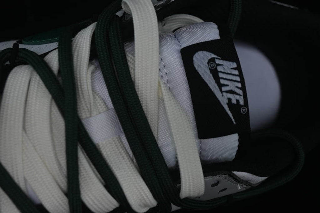 Close-up of layered white and green laces and tongue label
