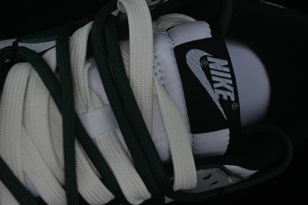 Close-up of layered white and green laces and tongue label