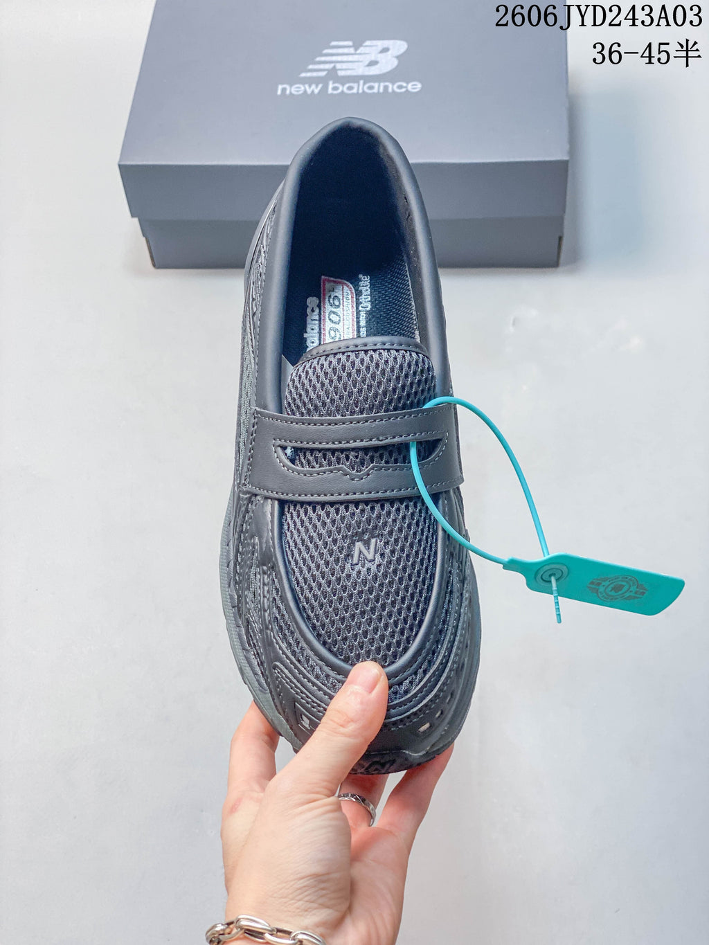 Top view of a charcoal gray New Balance 1906L loafer-style sneaker with mesh panels and instep strap