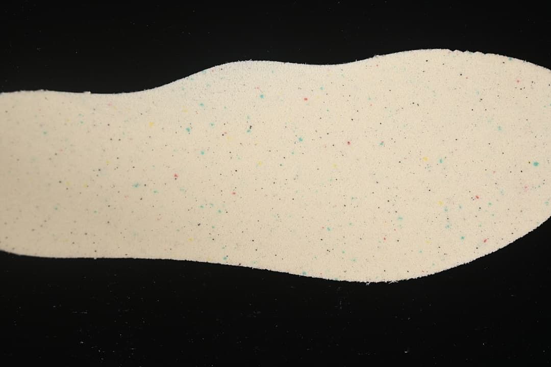 Light-colored shoe insole shown against a dark background