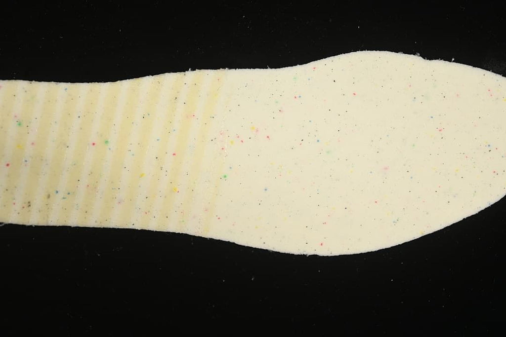 Close-up of a light-colored shoe insole with small multicolor speckles