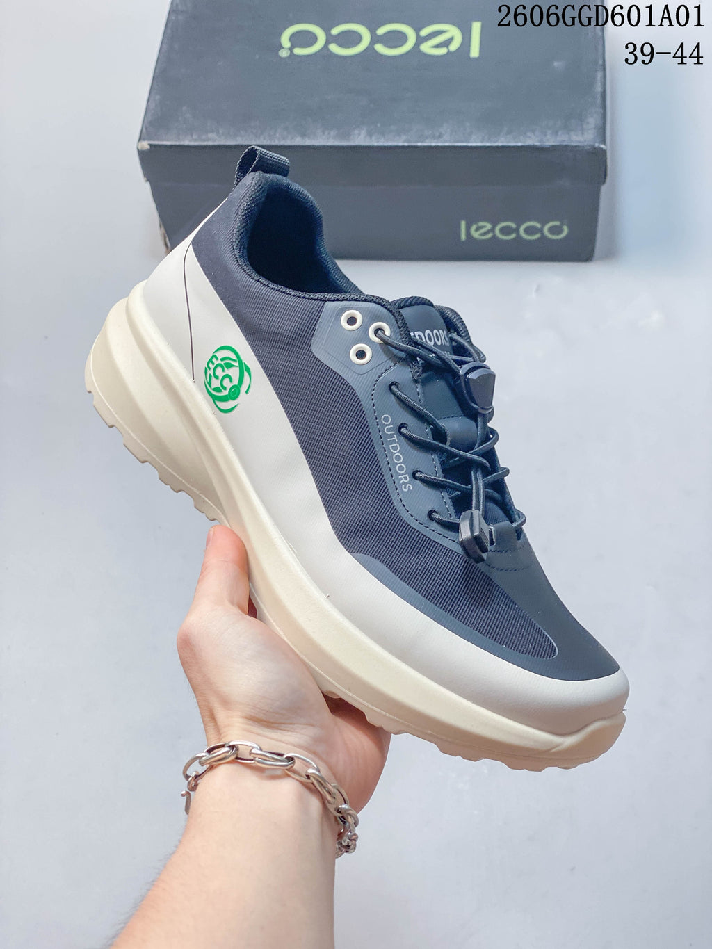 Angled side view showing the sneaker's navy and grey panels and green heel emblem