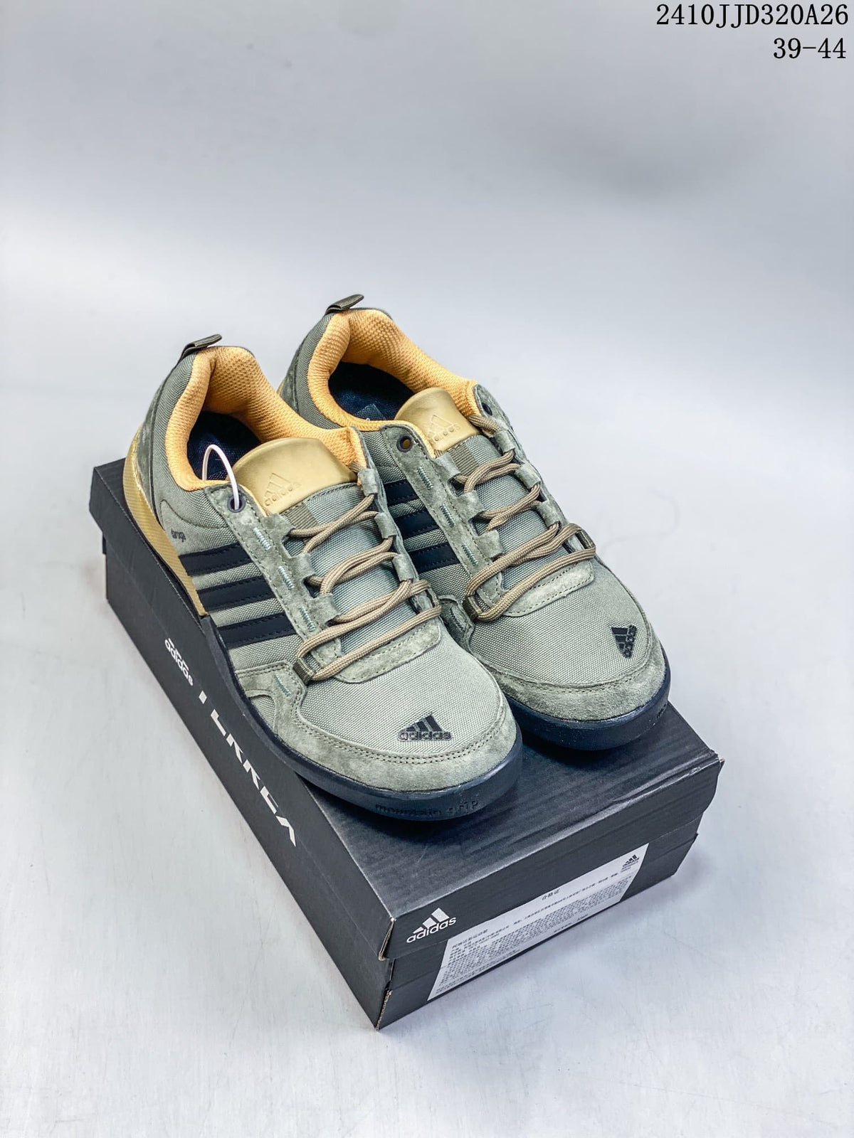 Pair of green adidas Daroga shoes with dark stripes and tan accents on a shoe box.