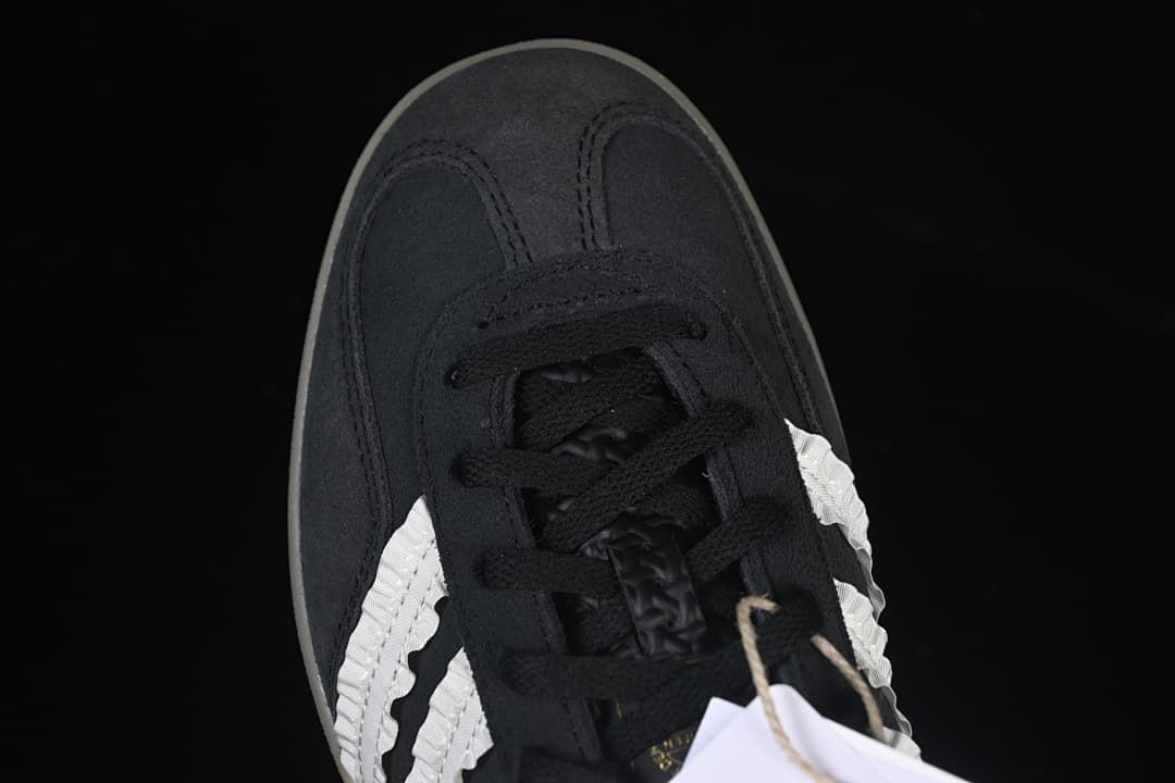 Top-down view of the black toe, laces and white side stripes.