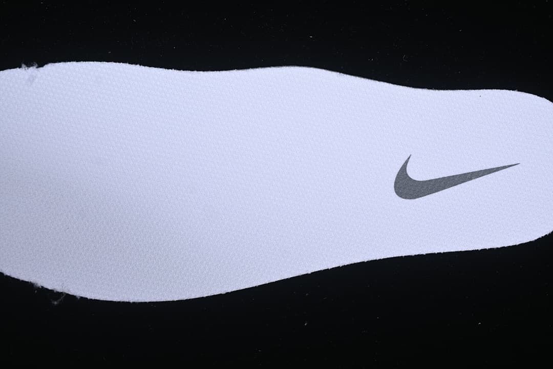 Close-up of a white insole with a dark Swoosh logo