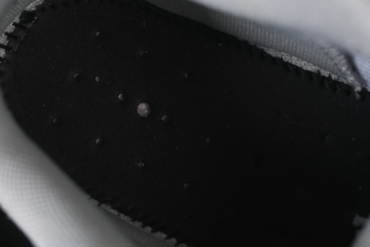 Close-up view inside the sneaker, showing a dark insole and light-colored lining.