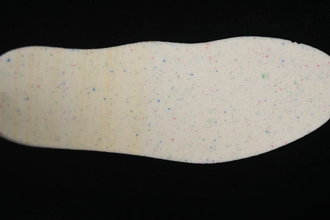 Light-colored removable shoe insert with scattered colored flecks