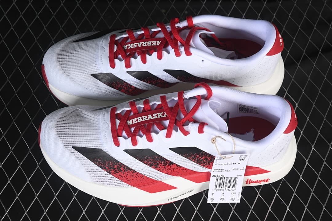 Pair of white, red, and black Adizero Evo SL shoes with Nebraska graphics