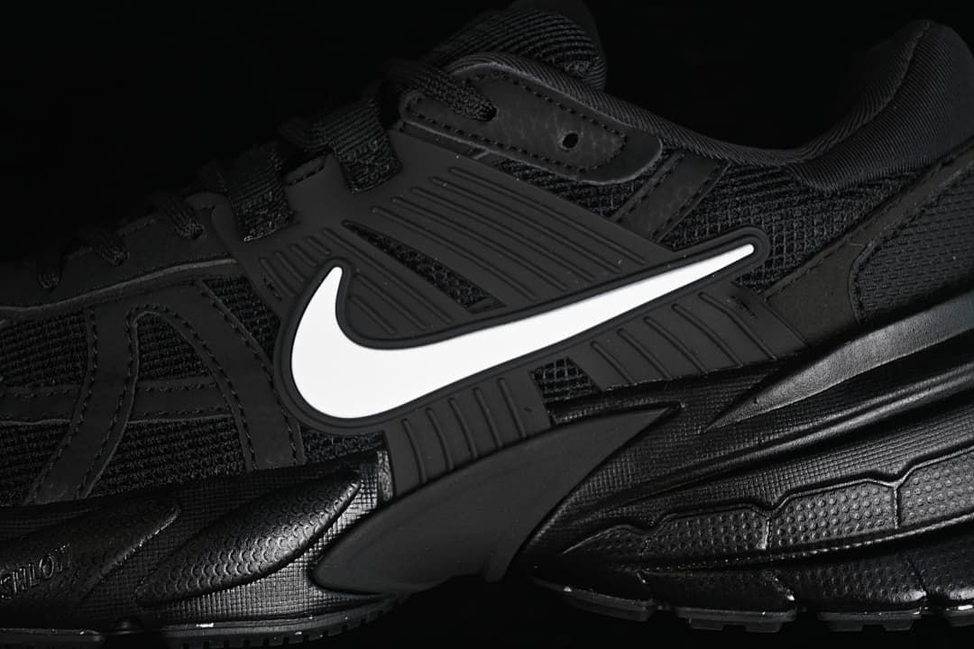 Close-up of the black mesh upper, layered side panels and white Swoosh.