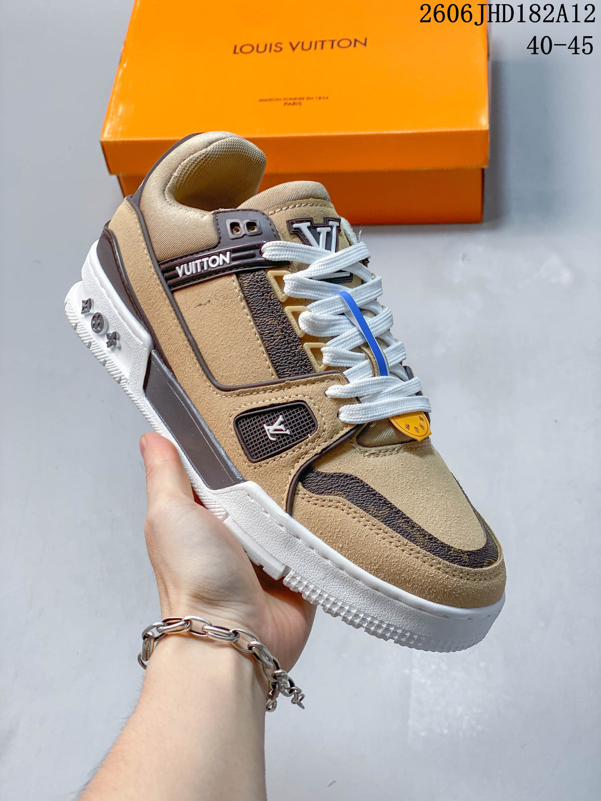 Close view of a beige Louis Vuitton Trainer sneaker with brown patterned accents and a white sole; image overlay reads 40–45.