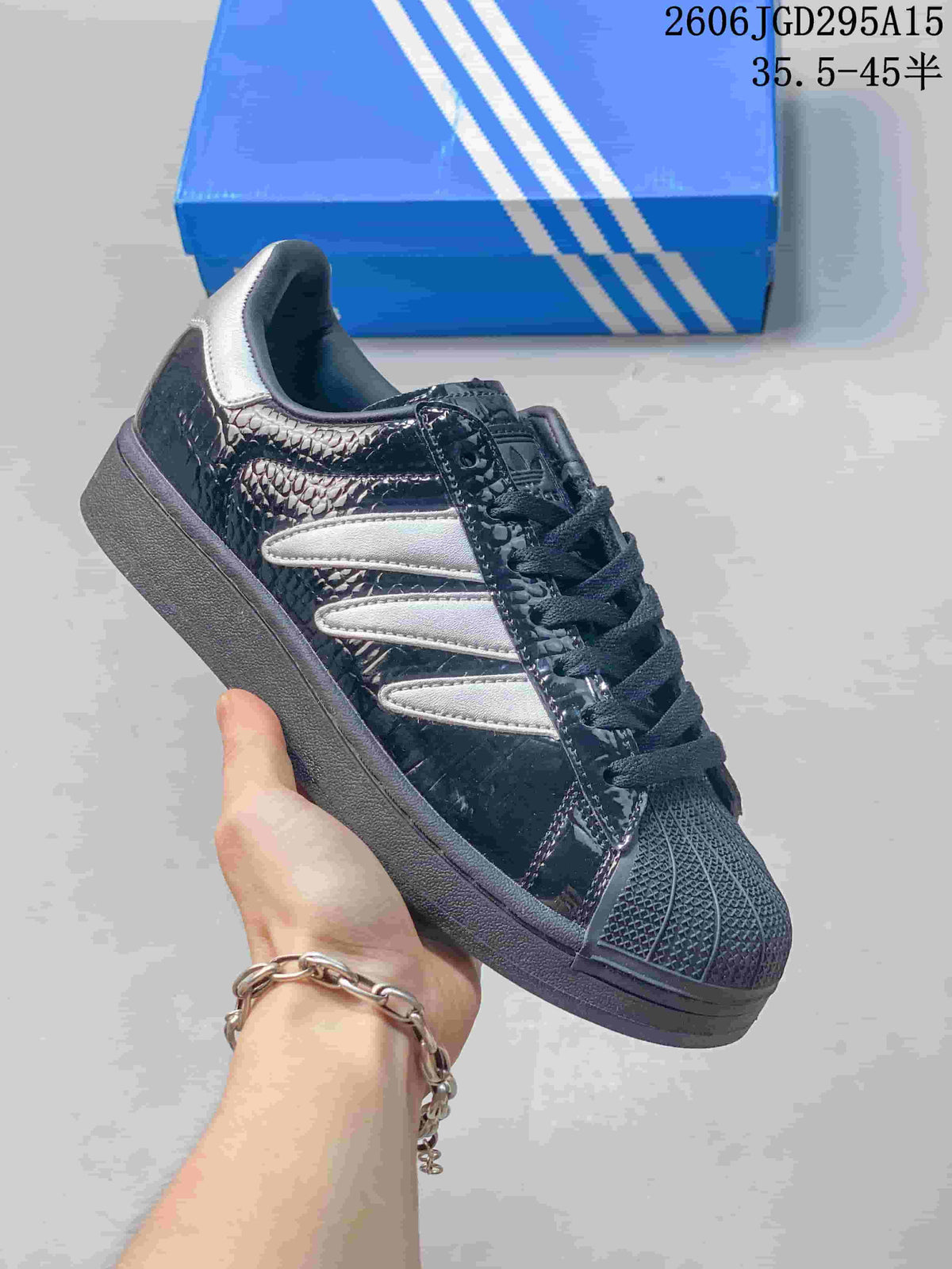 Dark glossy sneaker with white stripes and a textured shell toe