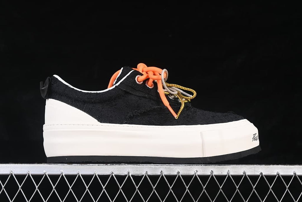 Side profile of a black sneaker with a thick white platform sole