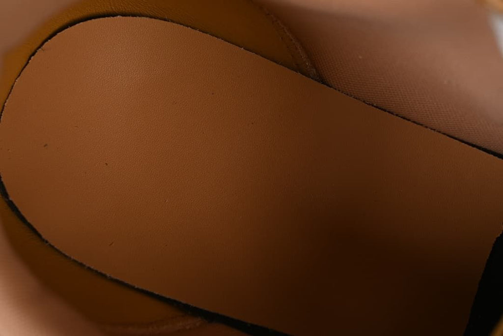 Close-up of the shoe's brown interior lining and footbed.