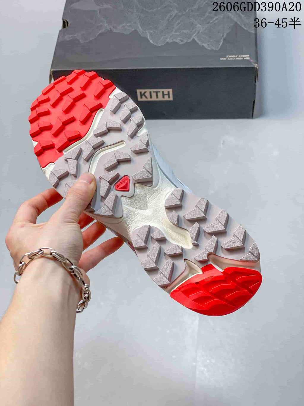Close-up of the lugged outsole with red and gray tread sections