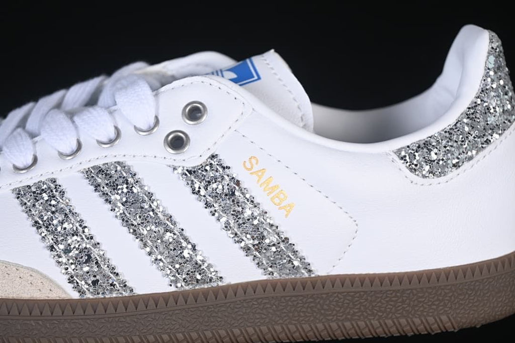 Close-up of the silver glitter-effect stripes, heel accent, and Samba side lettering.