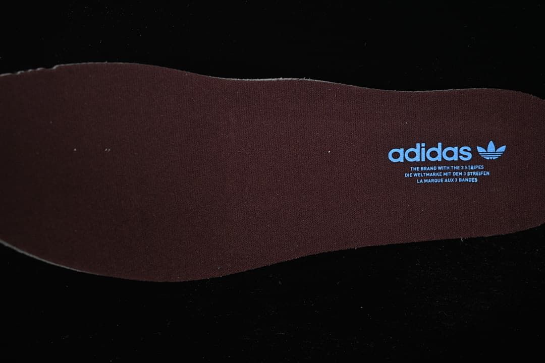 Brown insole with adidas Trefoil branding.