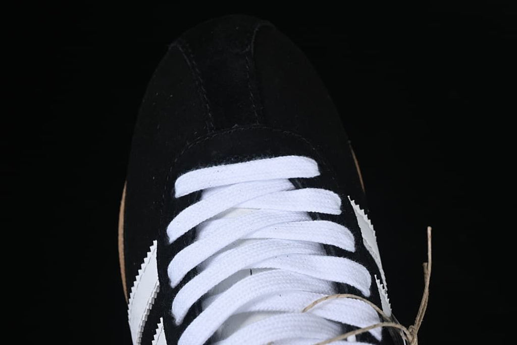 Top-down close-up of the white laces and black toe