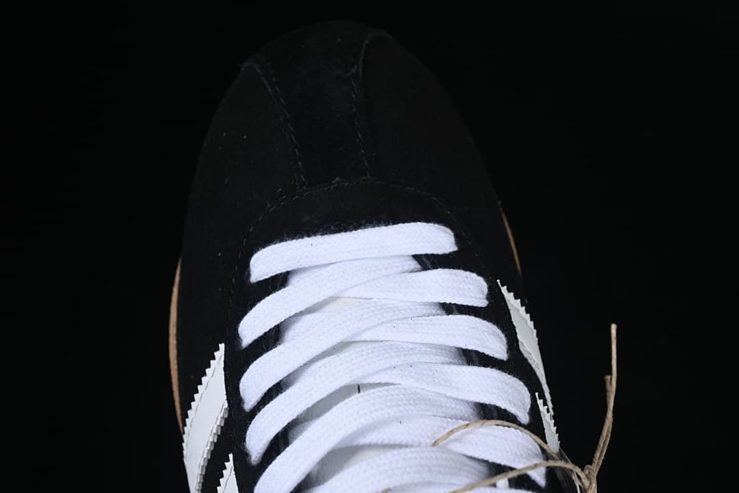Top-down close-up of the white laces and black toe
