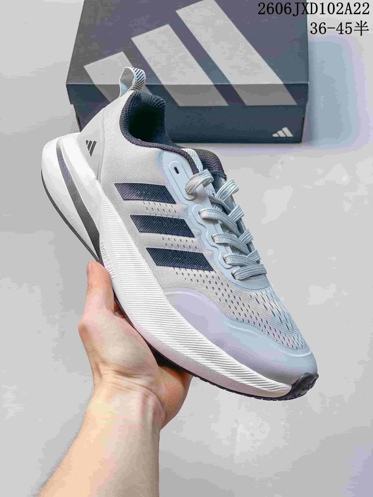Side view of a white Adidas sneaker with dark stripes and a thick ridged sole.