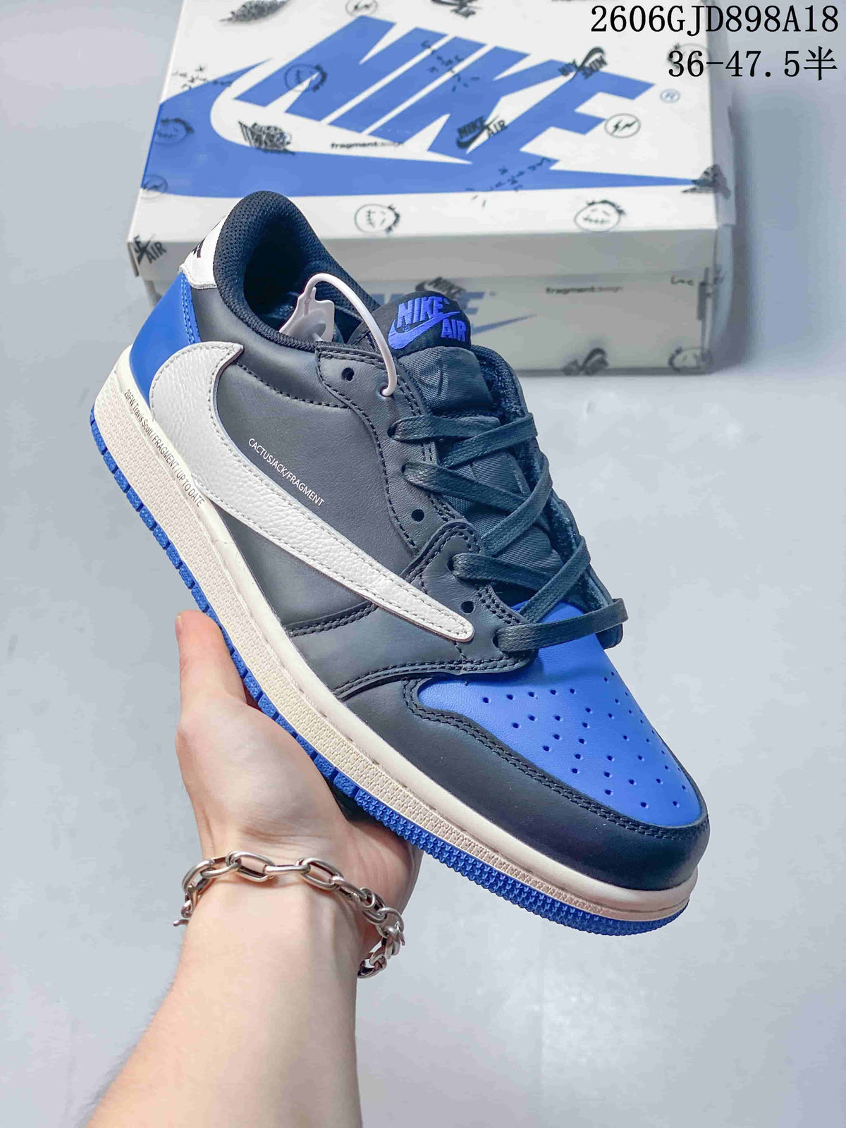 Close side view of the blue, dark grey, and off-white sneaker