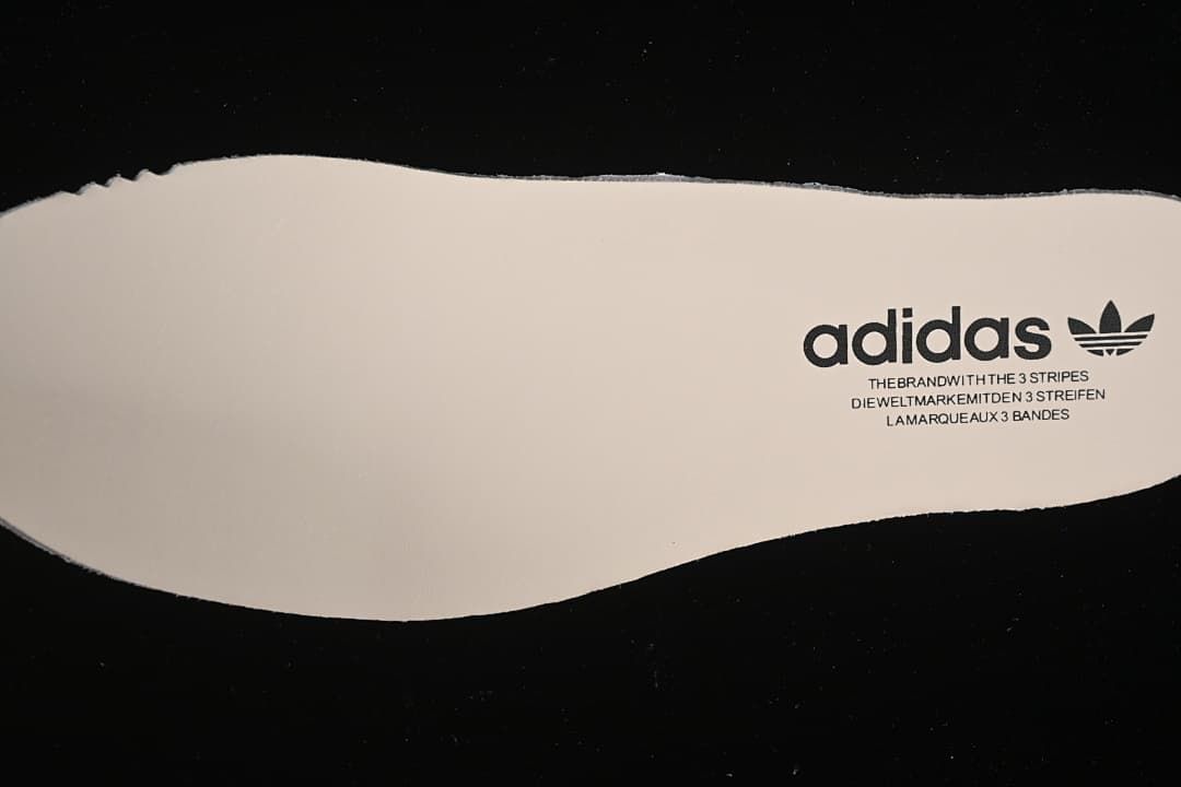 Light-colored insole with adidas Trefoil branding.