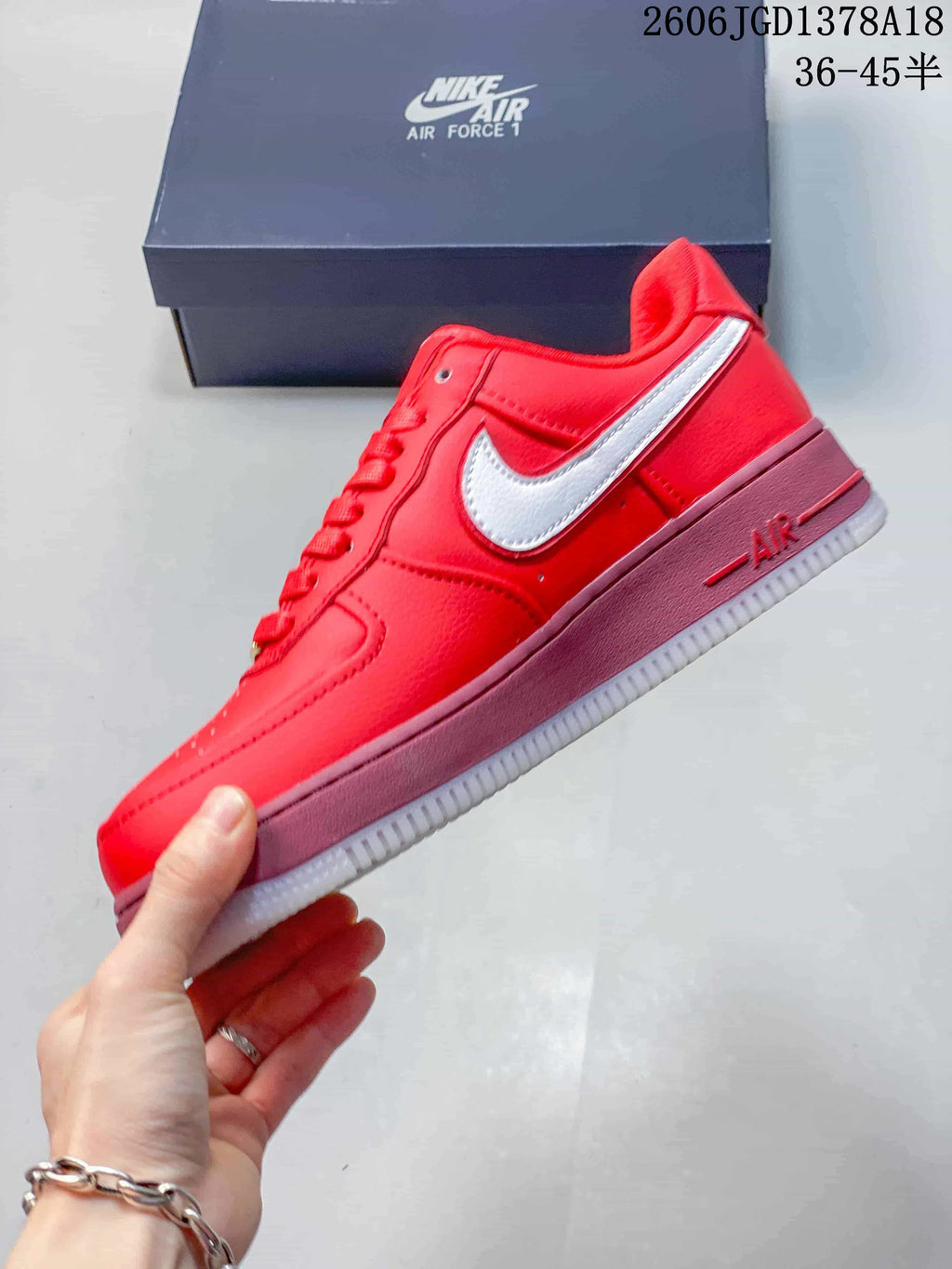 Side view of a red low-top sneaker with a white Swoosh and mauve-pink midsole
