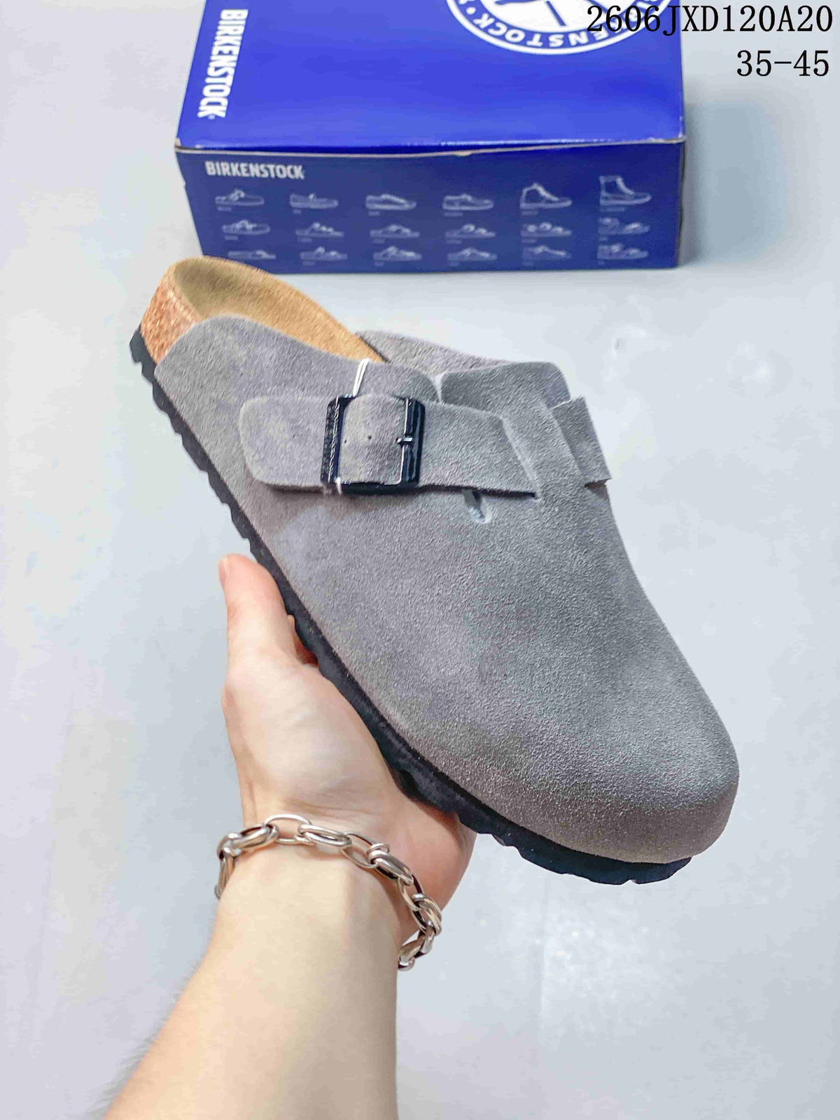 Angled view of the gray clog and adjustable buckle strap