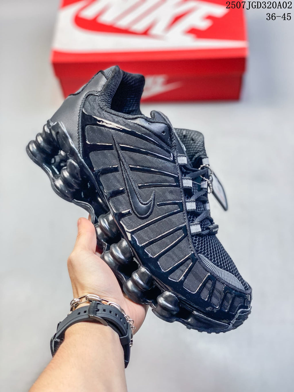 Side view of a black sneaker showing layered panels and column-shaped sole details