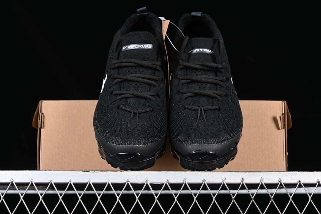 Front view of the pair showing black uppers, lace fastening, and tongue branding.