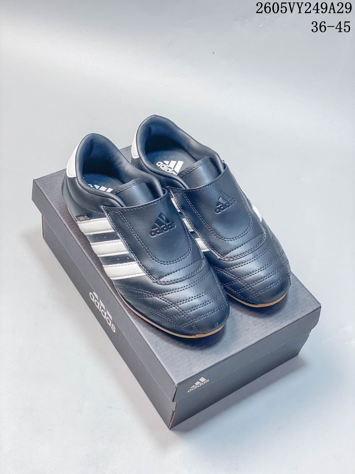 Pair of dark low-top shoes with broad instep straps and white side stripes.