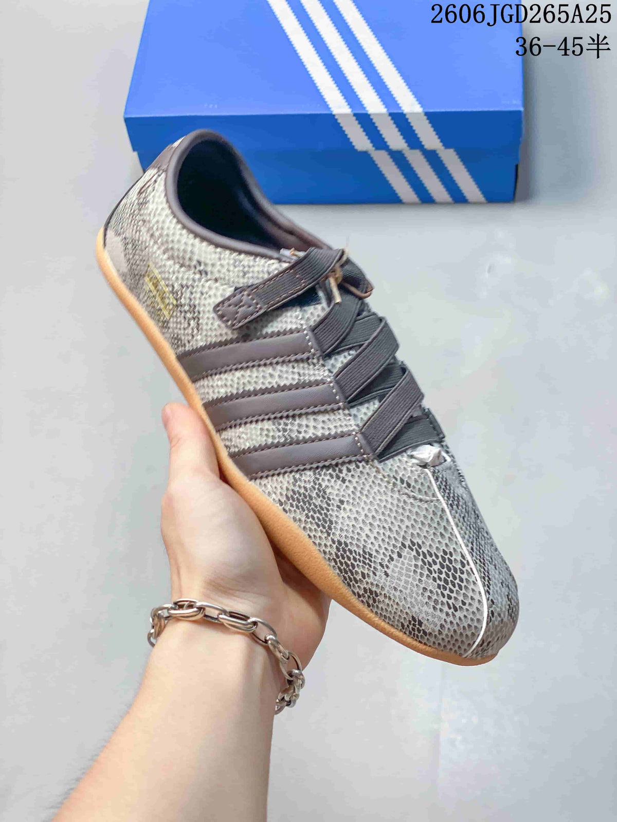 Close-up of a gray snakeskin-style print Adidas Tokyo W sneaker with dark stripes and crossing bands.