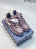 Mauve low-top Air Force 1 sneakers with white Swooshes, shown on a shoe box