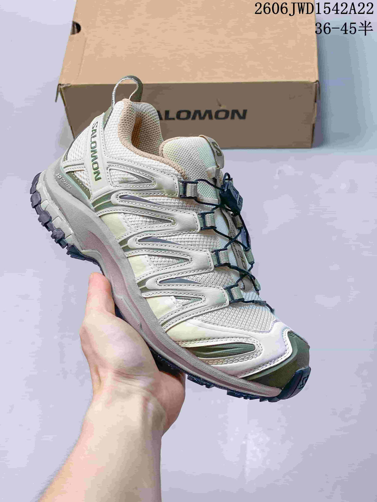 White Salomon trail-style sneaker with pale green accents and a lugged outsole.