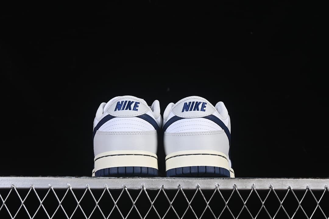 Rear view of both sneakers showing heel panels and navy outsoles
