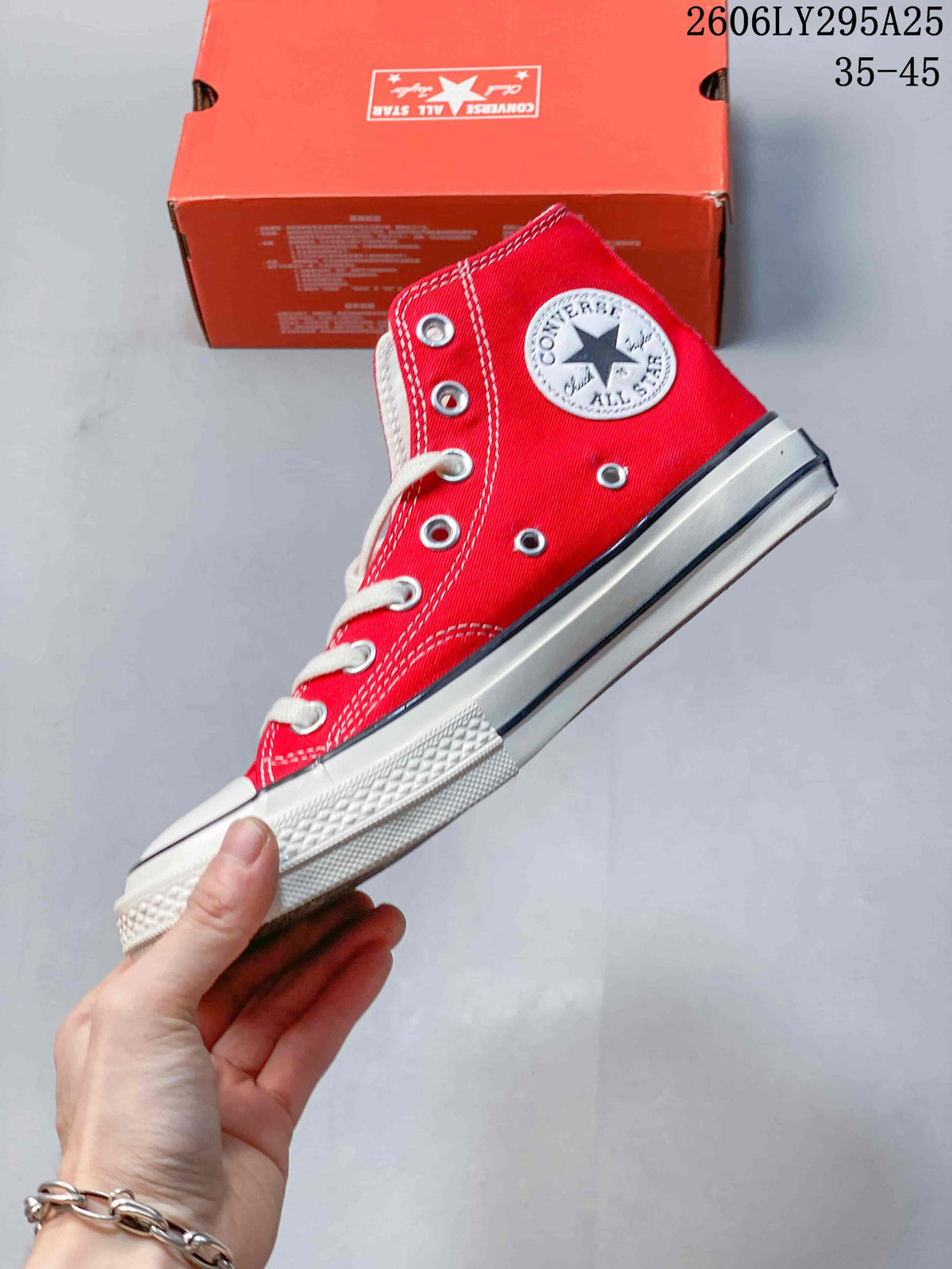 Side view of a red Converse Chuck Taylor All Star high-top sneaker with white stitching and laces
