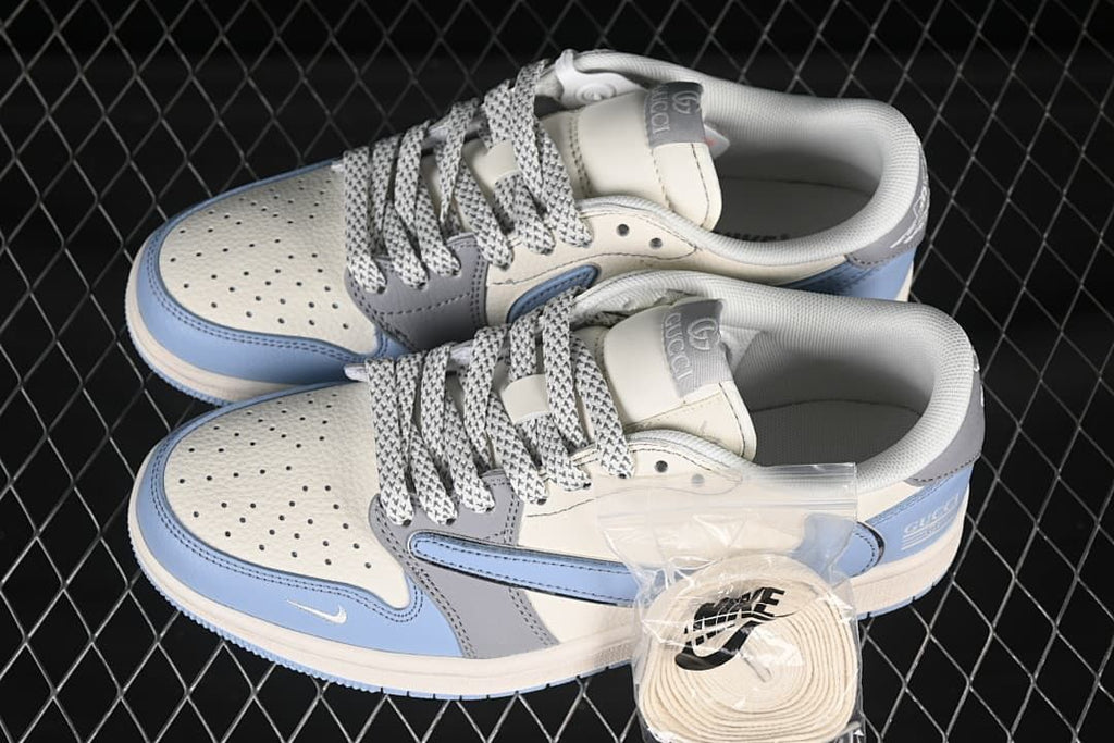 Top view of a pair of grey and blue low-top sneakers with patterned laces and an extra lace set
