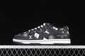 Side view of a black-and-white grid-pattern low-top sneaker with white stitching and logo-style details.