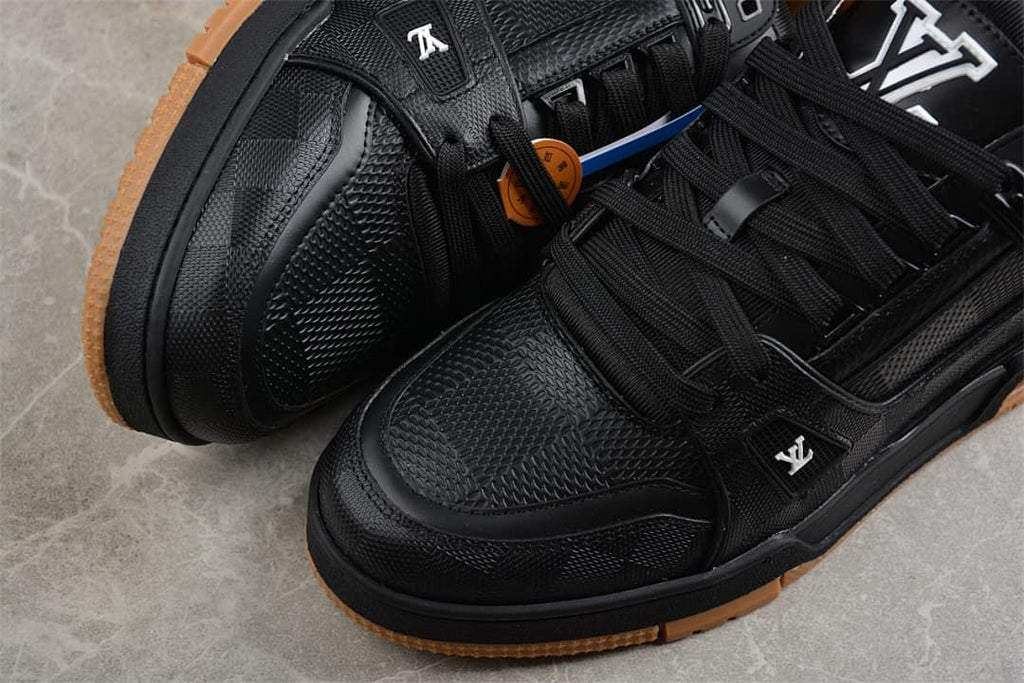 Close-up of the textured toe and lace-up areas of black sneakers